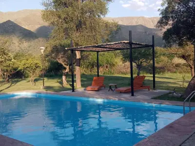 a pool with two chairs and a gazebo at Tayimapu in Merlo