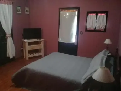 a bedroom with a bed and a television and a window at Tayimapu in Merlo