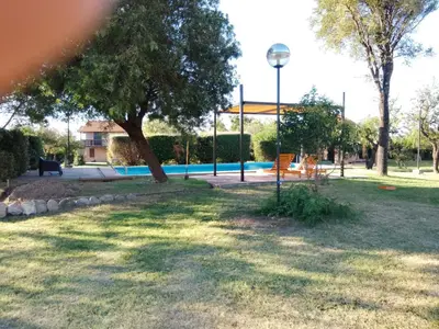 a park with a tree and a swimming pool at Tayimapu in Merlo
