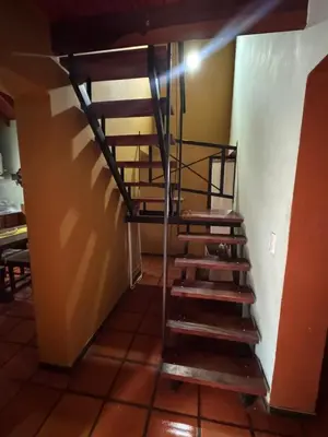 a metal spiral staircase in a room with a wall at Tayimapu in Merlo