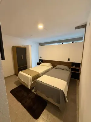a bedroom with two beds and a window at Quintaesencia Suites in Mina Clavero