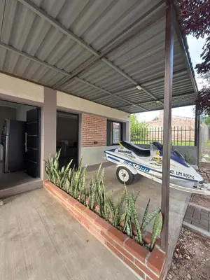 a house with a car parked under a garage at Quintaesencia Suites in Mina Clavero