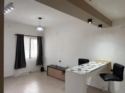 a living room with a counter and a table and chairs at Quintaesencia Suites in Mina Clavero