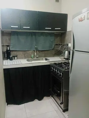 a kitchen with a stove and a refrigerator at Casa con pileta privada para 5 in Villa Carlos Paz
