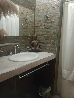 a bathroom with a sink and a mirror and a shower at Casa con pileta privada para 5 in Villa Carlos Paz