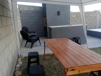 a patio with a wooden table and chairs and a tub at Casa con pileta privada para 5 in Villa Carlos Paz
