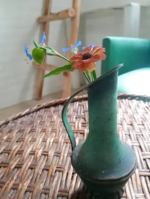 a green vase with flowers in it on a table at El paraíso de Tu Descanso in Villa de Las Rosas