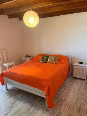 a bedroom with an orange bed with two pillows at El paraíso de Tu Descanso in Villa de Las Rosas