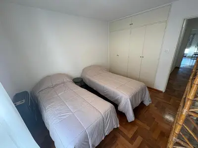 two beds in a room with white walls and wooden floors at Departamento amplio para 6 personas Zona Centro in Cordoba