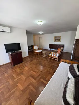 a living room with wooden floors and a flat screen tv at Departamento amplio para 6 personas Zona Centro in Cordoba