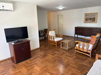 a living room with a flat screen tv and chairs at Departamento amplio para 6 personas Zona Centro in Cordoba