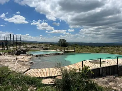 two pools of water with a wooden bridge in a field at Sauron Adventure in Cuesta Blanca