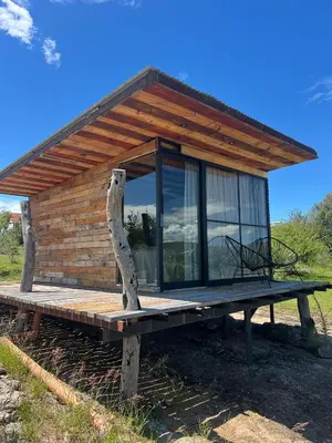 a log cabin with a large window on a platform at Sauron Adventure in Cuesta Blanca