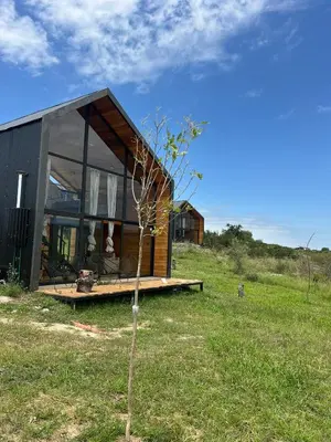 a small house on top of a grass field at Sauron Adventure in Cuesta Blanca