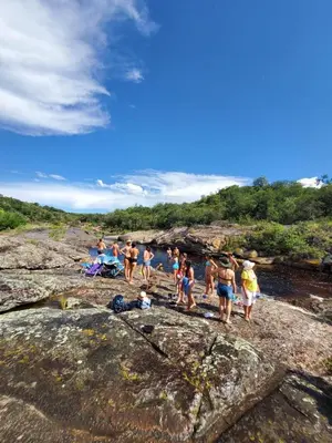 a group of people standing on rocks near a river at Sauron Adventure in Cuesta Blanca