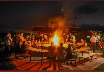 a group of people sitting around a fire at night at Sauron Adventure in Cuesta Blanca