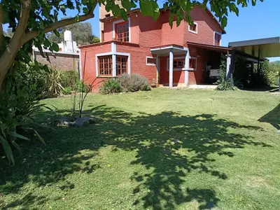 a large red brick house with a large yard at Altos de ensueños in Alpa Corral