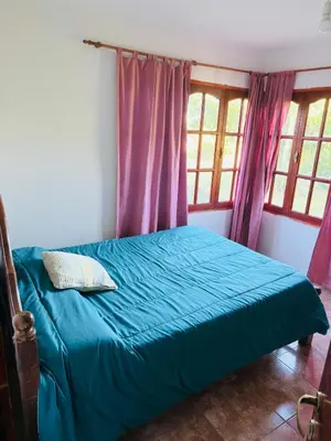 a bedroom with a blue bed with purple curtains at Altos de ensueños in Alpa Corral