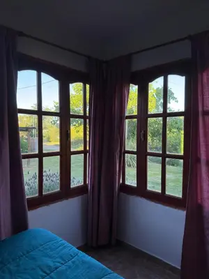 a bedroom with three windows and a bed with a bedspread at Altos de ensueños in Alpa Corral