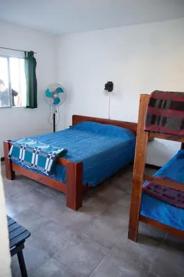 a bedroom with a bed with blue sheets and a chair at Parada 14 in Cavalango