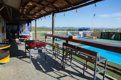 a patio with a table and benches next to a swimming pool at Parada 14 in Cavalango