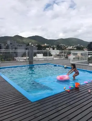 a young child playing in a pool on a roof at Vive Carlos Paz in Villa Carlos Paz