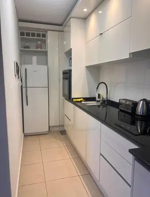 a kitchen with white cabinets and a white refrigerator at Vive Carlos Paz in Villa Carlos Paz