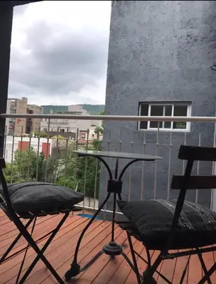 a balcony with two chairs and a table on a building at Vive Carlos Paz in Villa Carlos Paz