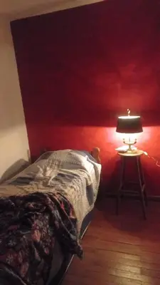 a bedroom with a bed and a table with a lamp at Casa Corna in Río Cuarto