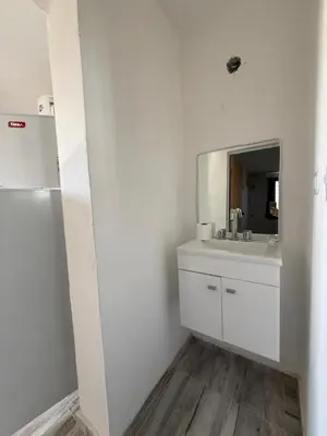 a white bathroom with a sink and a mirror at Cabaña El Bosquecito in Estancia Vieja