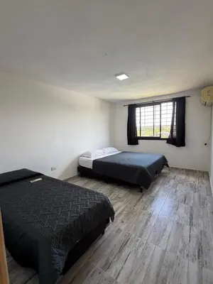 a bedroom with two beds and a wooden floor at Cabaña El Bosquecito in Estancia Vieja