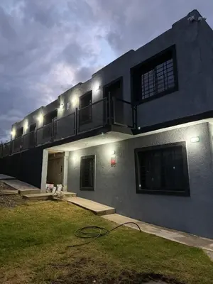 a building with a balcony with lights on it at Cabaña El Bosquecito in Estancia Vieja