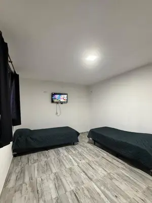 a room with two beds and a flat screen tv at Cabaña El Bosquecito in Estancia Vieja