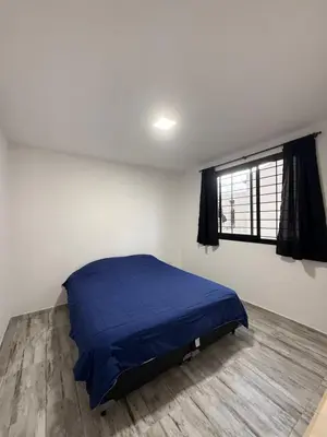 a bedroom with a blue bed and a window at Cabaña El Bosquecito in Estancia Vieja