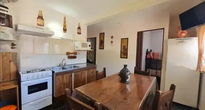 a kitchen with a wooden table and a refrigerator at Departamento Villa Carlos Paz Excelente Ubicación in Villa Carlos Paz
