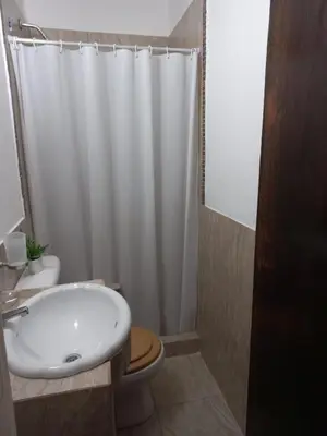 a bathroom with a white shower curtain and a toilet at Departamento Villa Carlos Paz Excelente Ubicación in Villa Carlos Paz
