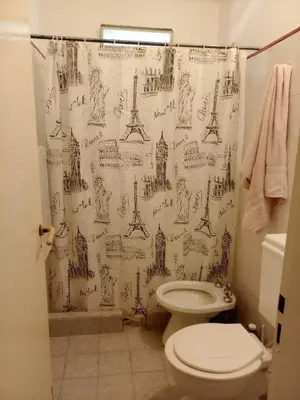 a bathroom with a shower curtain with drawings of monuments at La Serranita de Miguel in Villa Serranita