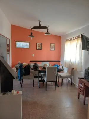 a living room with orange walls and a table and chairs at La Serranita de Miguel in Villa Serranita