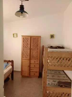 a bedroom with a bunk bed and a wooden cabinet at La Serranita de Miguel in Villa Serranita