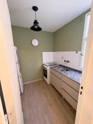 a small kitchen with a sink and a clock on the wall at Nuevocentro Apartment in Cordoba