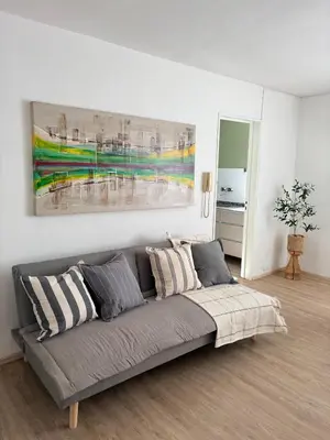 a couch in a living room with a painting on the wall at Nuevocentro Apartment in Cordoba