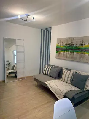 a living room with a couch and a mirror at Nuevocentro Apartment in Cordoba