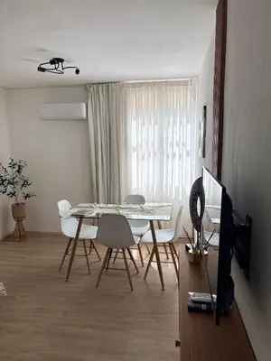 a dining room with a table and chairs and a television at Nuevocentro Apartment in Cordoba