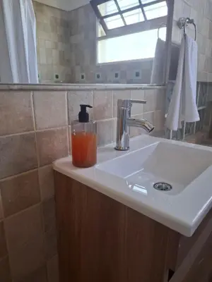 a bathroom sink with a drink in a glass at Monoambiente luminoso con Jacuzzi Relax y estilo in Cordoba