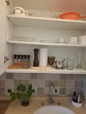 a kitchen shelf with dishes and utensils on it at Monoambiente luminoso con Jacuzzi Relax y estilo in Cordoba