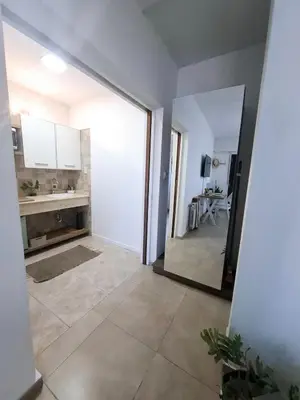 a kitchen with white cabinets and a large mirror at Monoambiente luminoso con Jacuzzi Relax y estilo in Cordoba
