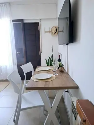 a dining room table with two chairs and a television at Monoambiente luminoso con Jacuzzi Relax y estilo in Cordoba