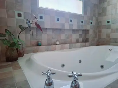 a white bath tub in a bathroom with a window at Monoambiente luminoso con Jacuzzi Relax y estilo in Cordoba