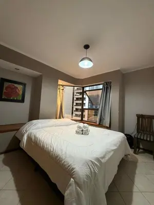 a bedroom with a large white bed with a window at Departamento alquiler temporal Nueva Cordoba in Cordoba