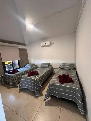 three beds in a room with red pillows on them at Sierras y Volcanes in Taninga